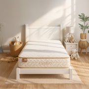 Mattress with 'Bamboo' label on a white bed frame in a bright bedroom.